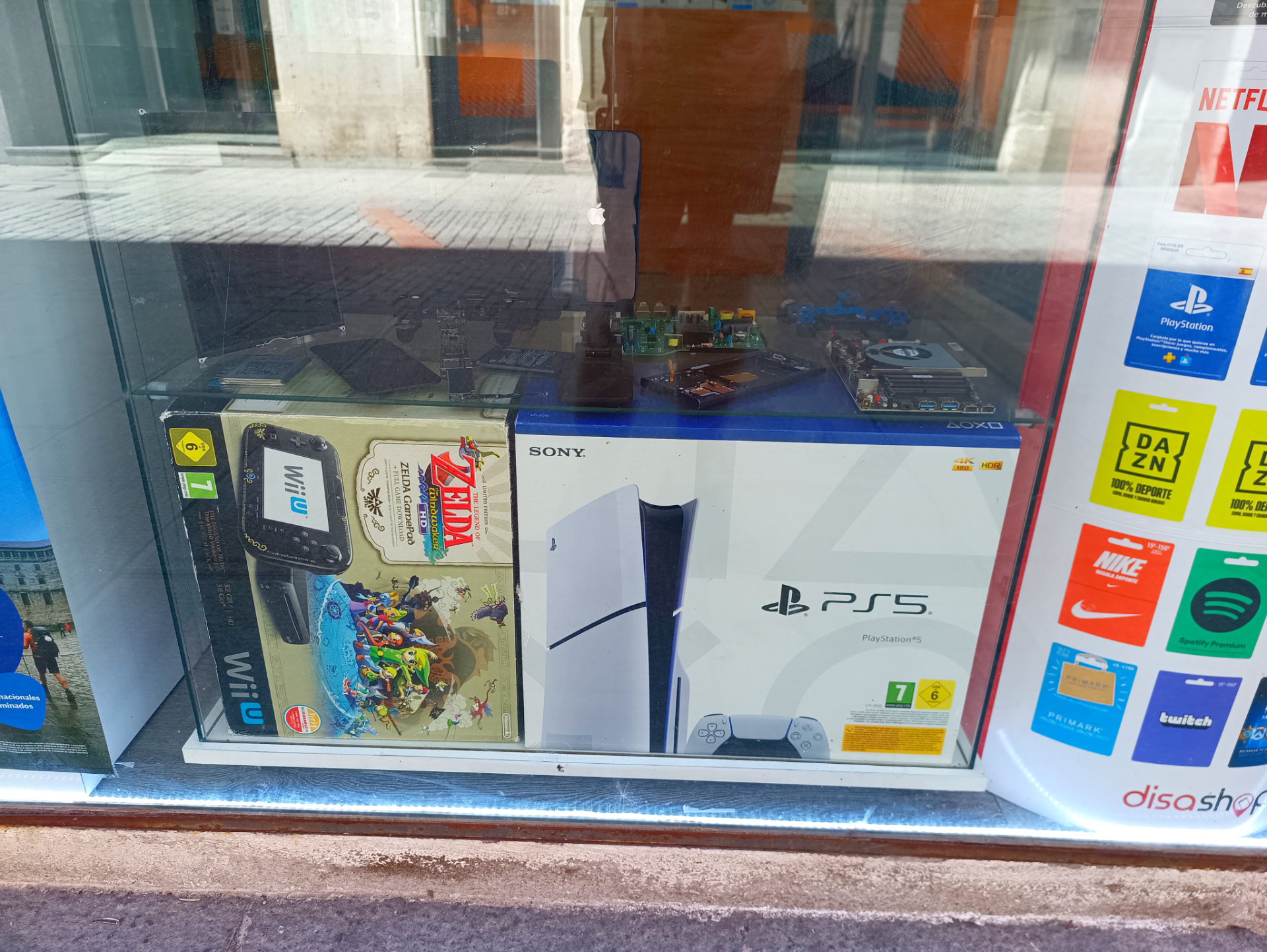 Escaparate con consolas PS5 y Wii U y placas de consola en reparación