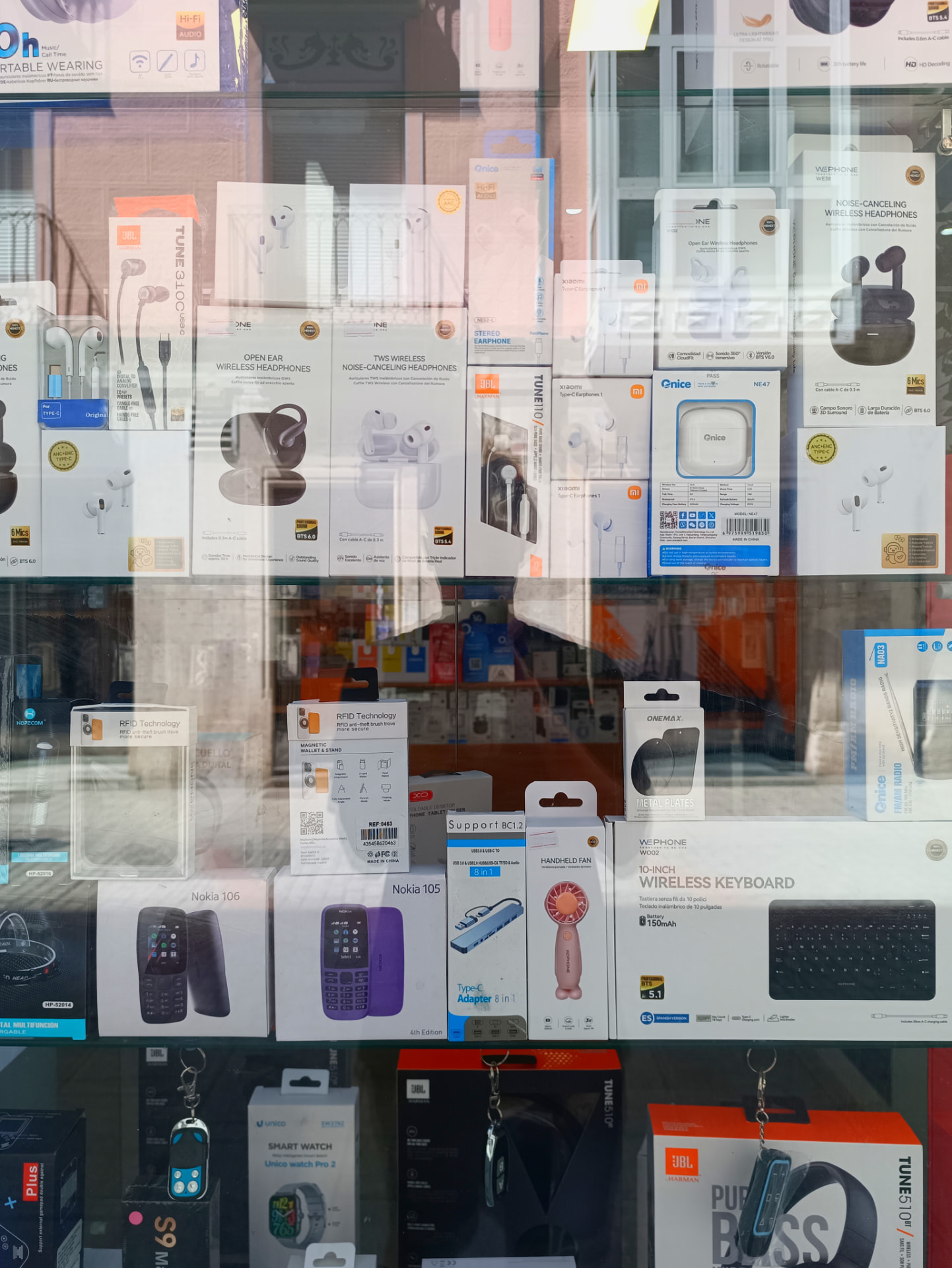 Escaparate con auriculares inalámbricos, teclados, smartwatches y accesorios